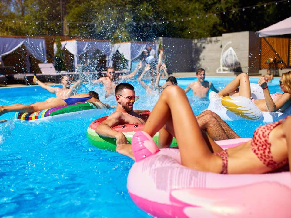 Resident enjoying a poolside party with a pink flamingo float.